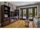 Living room featuring wood floors, built-in shelving, and glass doors leading to an outdoor space at 2511 W Morrison Ave, Tampa, FL 33629