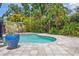 Secluded backyard oasis featuring a freeform pool, paver patio, and lush landscaping at 2511 W Morrison Ave, Tampa, FL 33629