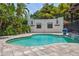 Lush tropical backyard featuring a freeform pool, paver patio, and privacy landscaping at 2511 W Morrison Ave, Tampa, FL 33629