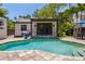 Beautiful pool area with a small pool house, a stone patio, and lush landscaping at 2511 W Morrison Ave, Tampa, FL 33629