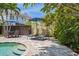 Relaxing poolside patio with lounge chairs, dining area, and lush tropical landscaping at 2511 W Morrison Ave, Tampa, FL 33629