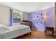 Bedroom with wood floors, natural light, and a lilac painted accent wall at 2646 61St N Ave, St Petersburg, FL 33714