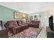 Comfortable living room with brown sofas, a colorful rug, and ample natural light from the windows at 2646 61St N Ave, St Petersburg, FL 33714