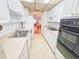 Galley kitchen features white cabinetry and appliances with view to the living area at 2850 59Th S St # 310, Gulfport, FL 33707