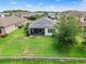 Aerial view of the home featuring a backyard with a screened lanai and lush landscaping at 30410 Ceasar Park Dr, Wesley Chapel, FL 33543