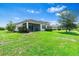 Spacious backyard featuring lush lawn and an extended screened lanai at 30410 Ceasar Park Dr, Wesley Chapel, FL 33543