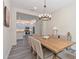 Open dining room with a view of a kitchen featuring stainless steel appliances, white cabinets, and stone countertops at 30410 Ceasar Park Dr, Wesley Chapel, FL 33543