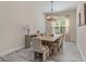Dining room featuring wood table with seating for eight, chandelier, and natural light from a window at 30410 Ceasar Park Dr, Wesley Chapel, FL 33543