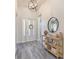 Welcoming foyer with decorative light fixture, wood-look tile, and console table at 30410 Ceasar Park Dr, Wesley Chapel, FL 33543