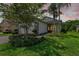 Home featuring a well-kept lawn, mature trees, and a stone-accented facade at 30410 Ceasar Park Dr, Wesley Chapel, FL 33543