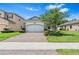 Beautiful home exterior with a brick driveway, manicured landscaping, and a two-car garage at 30410 Ceasar Park Dr, Wesley Chapel, FL 33543