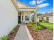 Inviting front entrance with stone pillar detail and charming bench seating on the porch at 30410 Ceasar Park Dr, Wesley Chapel, FL 33543