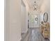 Bright hallway with wood-look tile, decorative lighting, and a stylish console table at 30410 Ceasar Park Dr, Wesley Chapel, FL 33543