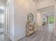 Hallway showcasing wood-look tile, neutral walls, and a view to the backyard at 30410 Ceasar Park Dr, Wesley Chapel, FL 33543