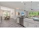 Spacious kitchen with island and a breakfast bar overlooking a dining area with a wood table and gray chairs at 30410 Ceasar Park Dr, Wesley Chapel, FL 33543