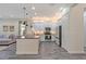 Spacious kitchen with white cabinets, kitchen island, stainless appliances, and view of living space at 30410 Ceasar Park Dr, Wesley Chapel, FL 33543