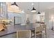 Bright kitchen featuring pendant lighting, gray cabinets, stainless appliances, and a gray countertop island with seating at 30410 Ceasar Park Dr, Wesley Chapel, FL 33543
