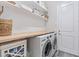 Functional laundry room featuring front-load washer and dryer with shelving at 30410 Ceasar Park Dr, Wesley Chapel, FL 33543