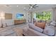 Bright living room featuring a comfortable sectional couch, entertainment center, and sliding glass doors to the patio at 30410 Ceasar Park Dr, Wesley Chapel, FL 33543