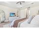 Bright bedroom with a tray ceiling, large bed, carpet, and a view into the en suite bathroom and walk-in closet at 30410 Ceasar Park Dr, Wesley Chapel, FL 33543