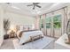 Bright main bedroom featuring a tray ceiling, plush carpet, a large bed, and plenty of natural light at 30410 Ceasar Park Dr, Wesley Chapel, FL 33543