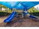 Community playground with slides under a blue shade canopy on a mulch surface at 30410 Ceasar Park Dr, Wesley Chapel, FL 33543