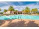 Community pool and patio area with a variety of seating and lush tropical landscaping at 30410 Ceasar Park Dr, Wesley Chapel, FL 33543