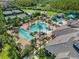 Aerial view of large community pool featuring lap lanes, ample lounge chairs and a water slide at 30410 Ceasar Park Dr, Wesley Chapel, FL 33543