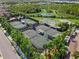 Aerial view of multiple well-maintained tennis courts, basketball court, and sand volleyball area at 30410 Ceasar Park Dr, Wesley Chapel, FL 33543