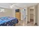 Comfortable bedroom featuring light wood floors, a ceiling fan, and access to both a closet and en suite bathroom at 3547 Odom Dr, New Port Richey, FL 34652