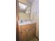 Bathroom featuring wood cabinets, a framed mirror and decorative wallpaper at 37229 Lois Ave, Zephyrhills, FL 33542