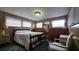Bedroom with windows, desk, dresser, lamp, chair and comfortable bed at 37229 Lois Ave, Zephyrhills, FL 33542