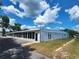 Exterior of the clubhouse with ample parking, an American flag, and a well-maintained lawn at 37229 Lois Ave, Zephyrhills, FL 33542