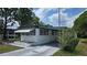 View of this single-story home featuring a carport, and manicured lawn at 37229 Lois Ave, Zephyrhills, FL 33542