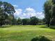 Picturesque golf course with green grass, trees, and blue sky at 37229 Lois Ave, Zephyrhills, FL 33542
