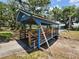 Charming pedestrian bridge painted in blue with wooden railings, surrounded by lush greenery in a community park at 37229 Lois Ave, Zephyrhills, FL 33542