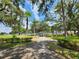 Inviting walking path surrounded by lush greenery, leading to a covered seating area in a serene community at 37229 Lois Ave, Zephyrhills, FL 33542