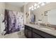Bathroom featuring double vanity, granite counters, stylish lighting, and a shower with decorative shower curtain at 3972 Wisdom Trl, Land O Lakes, FL 34638