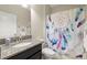 Bright bathroom with a granite-topped vanity and a shower with a dreamcatcher shower curtain at 3972 Wisdom Trl, Land O Lakes, FL 34638
