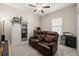 Cozy bedroom with a leather reclining loveseat, a sliding barn door, and neutral carpet at 3972 Wisdom Trl, Land O Lakes, FL 34638