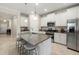 Modern kitchen featuring white cabinetry, granite countertops, a stainless steel microwave, and a central island at 3972 Wisdom Trl, Land O Lakes, FL 34638