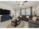 Cozy living room with plush sectional, large windows, and access to another room, creating a bright, relaxing ambiance at 3972 Wisdom Trl, Land O Lakes, FL 34638