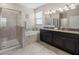 Luxurious primary bathroom with a soaking tub, glass enclosed shower, and dual granite-topped vanity at 3972 Wisdom Trl, Land O Lakes, FL 34638