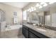 A full view of the primary bathroom showing granite countertop vanity, soaking tub and glass enclosed shower at 3972 Wisdom Trl, Land O Lakes, FL 34638