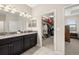 A full view of the primary bathroom showing granite countertop vanity and the walk-in closet entrance at 3972 Wisdom Trl, Land O Lakes, FL 34638