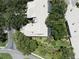Aerial view of a home with mature trees, a screened-in porch, and perfectly manicured landscaping at 423 Fan Palm Ne Ct, St Petersburg, FL 33703