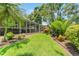 Manicured lawn surrounded by tropical plants and brick-lined garden beds at 423 Fan Palm Ne Ct, St Petersburg, FL 33703