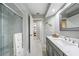 Bright bathroom showcasing a gray vanity with a marble countertop and a glass-enclosed shower at 423 Fan Palm Ne Ct, St Petersburg, FL 33703