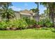 Well-maintained home exterior with lush landscaping, grass lawn and potted flowers at 423 Fan Palm Ne Ct, St Petersburg, FL 33703