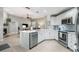Open-concept kitchen featuring white cabinets, stainless steel appliances, and a seamless view into the adjacent living area at 423 Fan Palm Ne Ct, St Petersburg, FL 33703